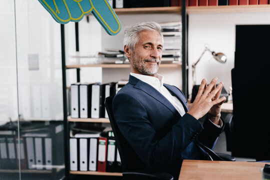 Finger pointing on confident mature businessman in office
