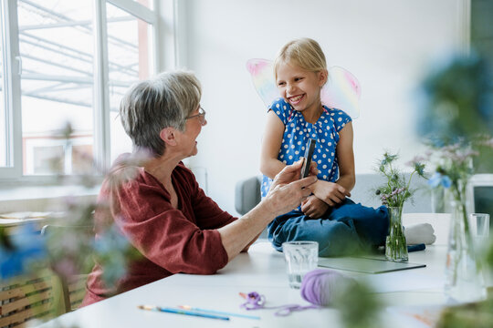 Grandmother and grandchild playing with smartphone at home