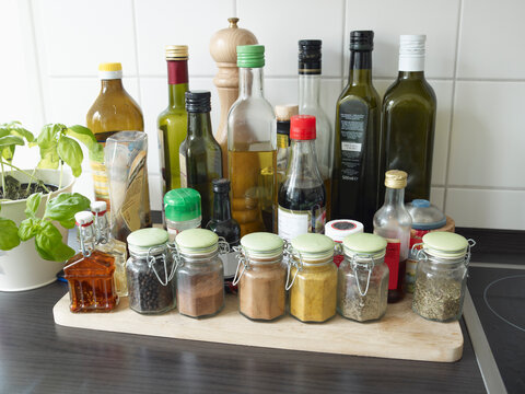 Glasses with herbs and spices in kitchen