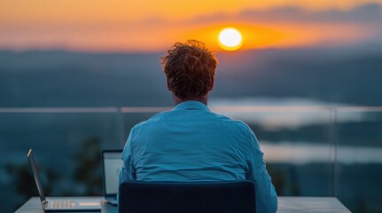 Fototapeta premium Man working on laptop as a remote person using technology during golden sunset
