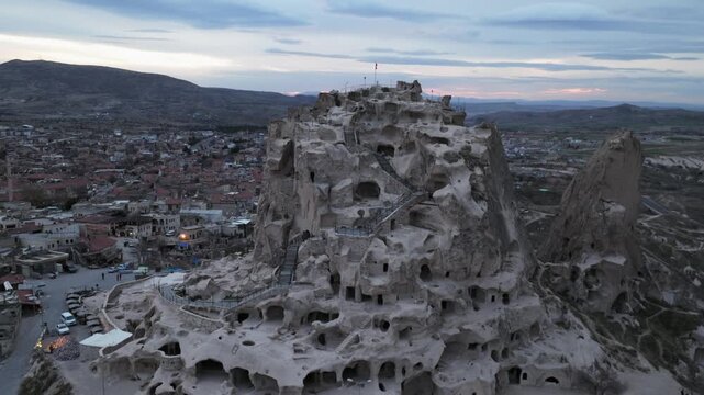 Drone view of Ortahisar Castle towering above the historic town of Ortahisar in Cappadocia, Turkey. A remarkable example of rock-carved architecture.