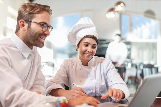 Restaurant chef and manager discussing menu