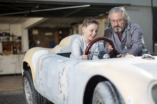Senior man explaining convertible to boy