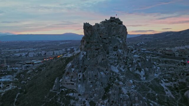 Drone view of Ortahisar Castle towering above the historic town of Ortahisar in Cappadocia, Turkey. A remarkable example of rock-carved architecture.