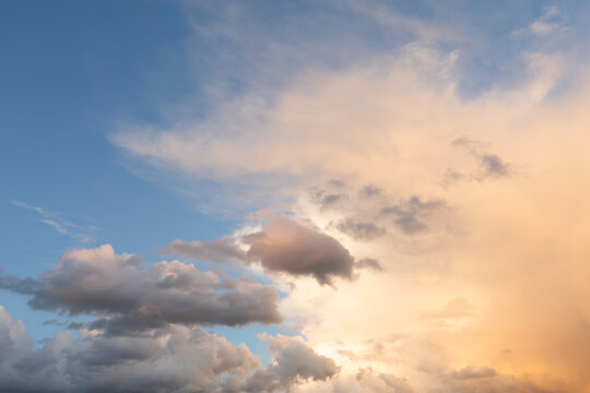Dramatic orange tinted clouds in a blue sky cloudscapr