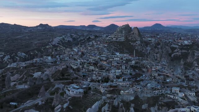 Drone view of Ortahisar Castle towering above the historic town of Ortahisar in Cappadocia, Turkey. A remarkable example of rock-carved architecture.