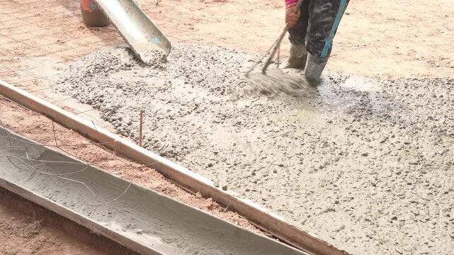 Close Up Of Wet Concrete Mix Flowing From Truck Mixer Into Rebar Mesh Formwork