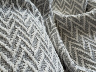 Knitted gray and white herringbone textured fabric background with intricate woven pattern © dvoevnore