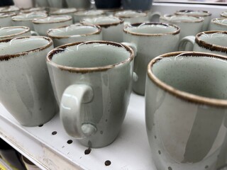 Ceramic coffee mugs display on white shelf in store offers variety of options for beverage lovers © dvoevnore