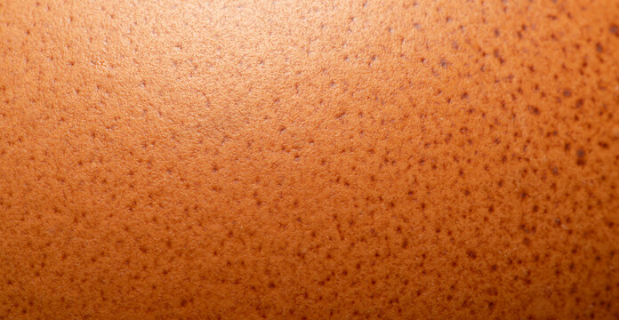 Macro Texture of a Brown Chicken Eggshell,Close-up macro photography detail showing the natural speckled pattern and porous texture of a brown chicken eggshell surface.