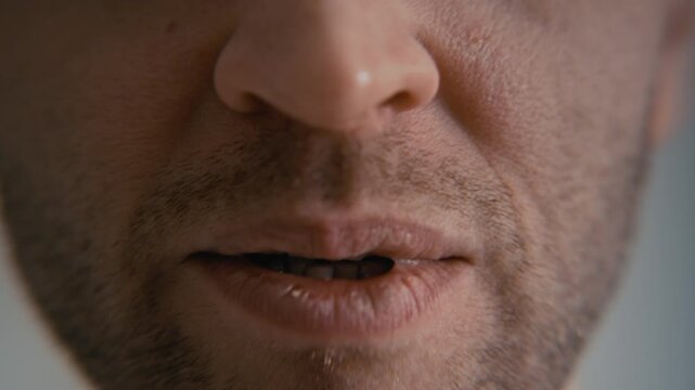 Tilt down close up of middle aged Caucasian man with mental illness moving eyes erratically and talking with creepy smile, ideal for psychiatric health campaigns or psychological drama trailers