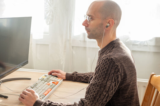 Programmer, young man in brown cable knit sweater working at computer, coding process, modern worker solving problems, specialist digital tasks, home office environment promoting productivity and calm
