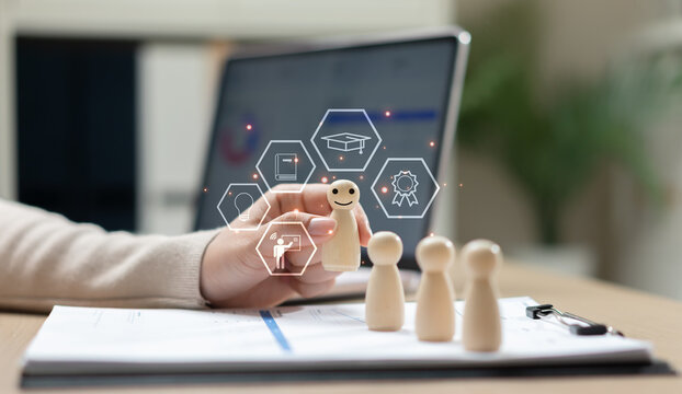 Employee training and professional development concept with wooden figures, digital learning icons and laptop. Workforce education, skill improvement, leadership training and talent management.