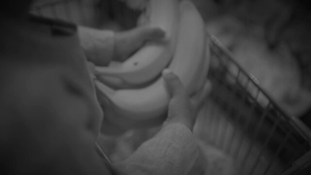 Hands placing stacked ceramic bowls into metal shopping basket in store