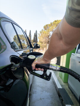 Close up of man refueling black car at gas station