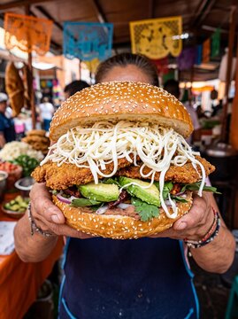 Traditional Mexican cemita poblana sandwich held by vendor at local market