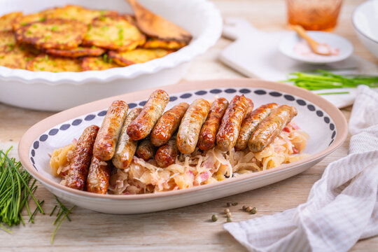 Small German sausages, Nuremberg  sausages with sauerkraut and potato pancakes