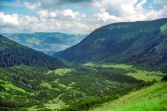 Panoramic view of the Hoverla glacial cirque in the Chornohora Range, Ukrainian Carpathians. Forested valleys, alpine meadows and mountain ridges under dramatic summer clouds