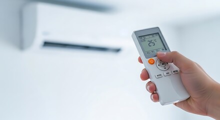 Fototapeta premium Person Using Remote Control to Operate Air Conditioner in Modern Room