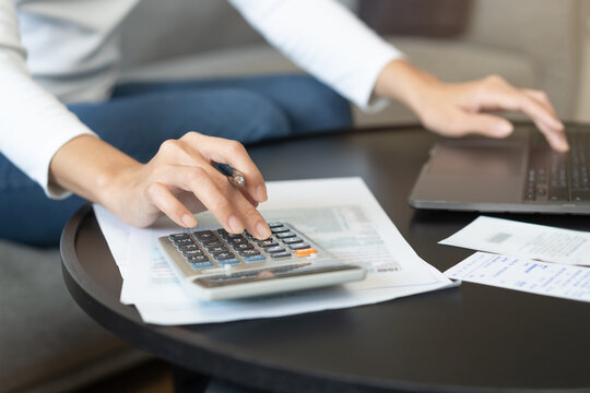 Deduction planning online asian young woman hand using calculator and laptop to calculate balance prepare tax reduction income, cost budget expenses for pay money form personal Individual Income.