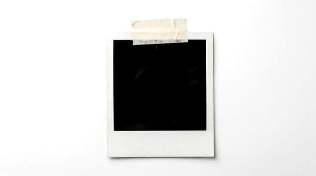 A blank polaroid photo with tape on a white background