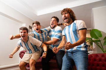 Grupo de amigos argentinos celebrando un gol mientras ven un partido de fútbol © Matias Lee