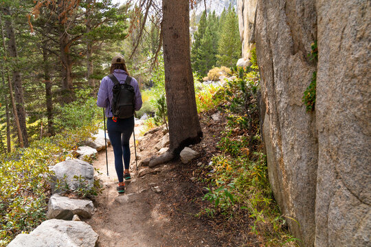 woman with backpack walking on hike exploring trail 