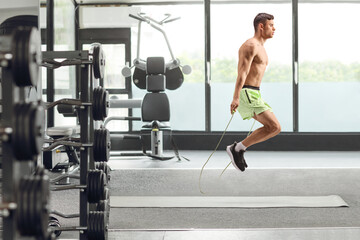 Fototapeta premium Young fit man jumping a rope
