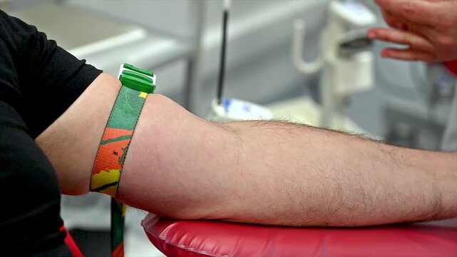 Close-up of a nurse disinfecting a blood donor arm with an antiseptic swab before venipuncture at a clinic illustrating hygiene and preparation for blood donation.