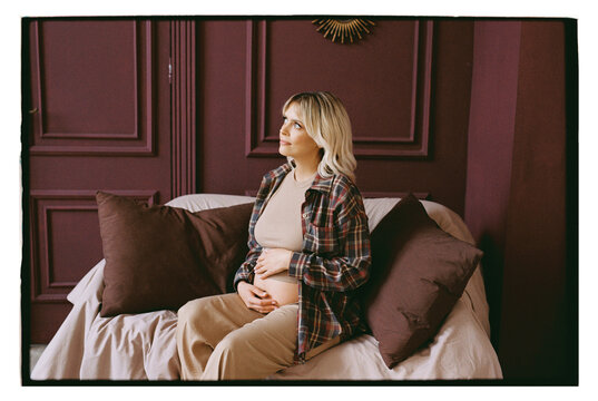 A pregnant woman holds her hands on her stomach.