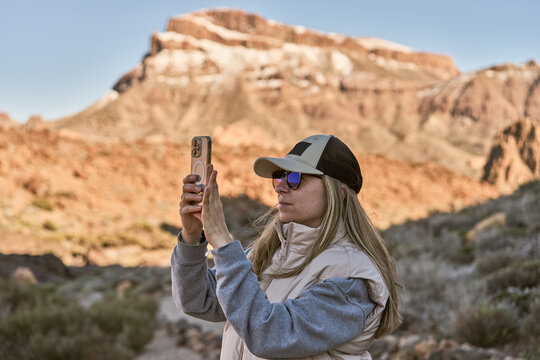 Woman Taking Photo With Smartphone In Desert Landscape