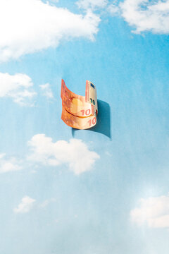 Curved euro banknote on blue sky background