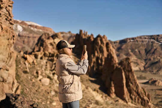 Woman Taking Photo With Smartphone In Desert Landscape