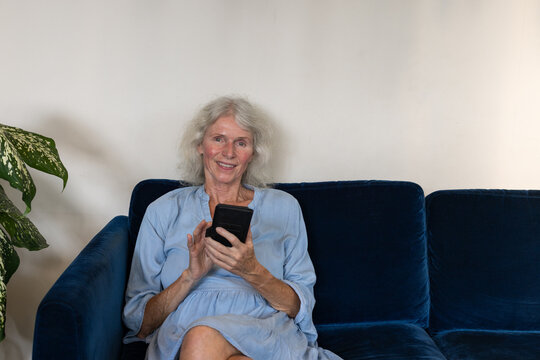 smiling senior woman with smartphone, portrait looking at camera