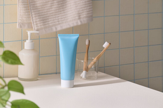 Minimalist bathroom counter with blue toothpaste tube and toothbrushes