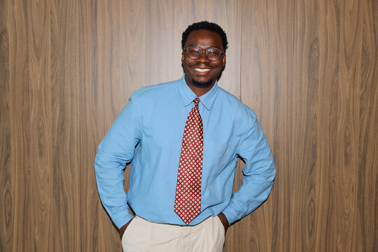 Businessman Smiles Against a Wooden Backdrop