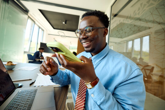 Businessman sits at a desk in a shared office, uses his phone
