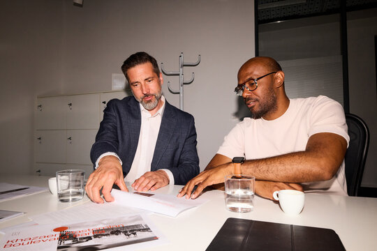 Two men discuss project indoors
