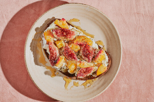 Slices of figs and peach on a bread with cottage cheese 