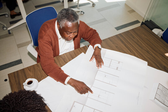 Senior man discusses building plans with his colleague