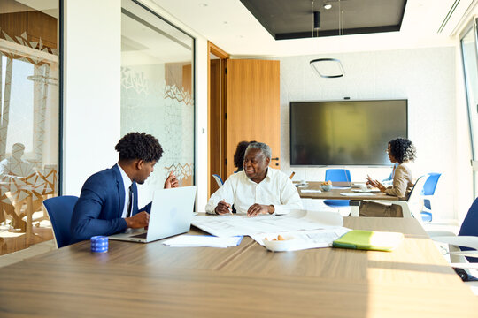 Two Men Discussing Plans in an Office Space