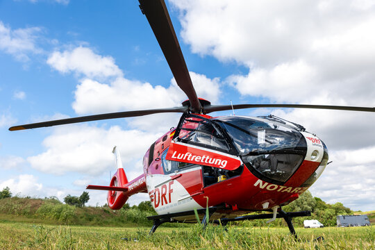 Mageburg, Germany - June 7, 2026. DRF Luftrettung German Air Rescue D-HRTB AIRBUS  rescue helicopter standing on grassy field under dramatic cloudy sky. Emergency medical aviation