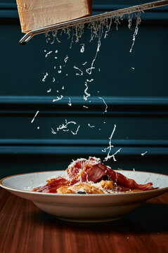 Parmesan cheese being grated onto the Cezar salad 