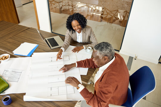 A man and a woman discuss plans in an office space