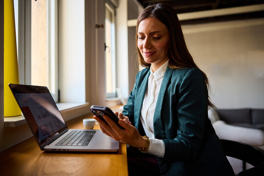 Beautiful woman uses a mobile phone at the office