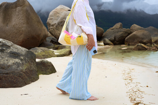 Walking along the beach with a bag in hand