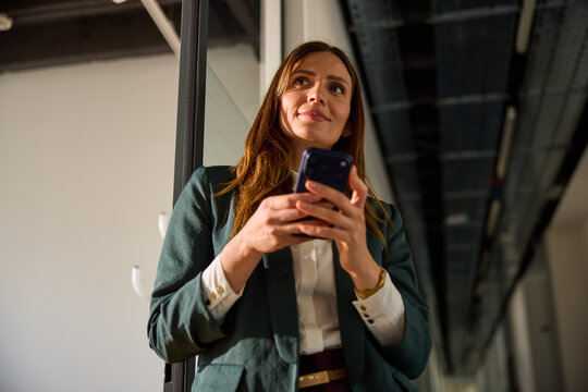 Beautiful woman holds a mobile phone inside the corporation