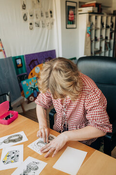 Female artist working on charcoal sketches at home studio desk