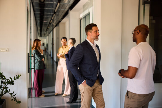 A group of colleagues gathered in the hallway