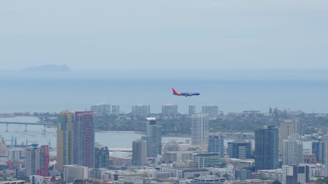 Southwest Airlines plane landing at San Diego International Airport with downtown San Diego skyline, Balboa Park, Coronado Bridge, Naval Air Station North Island